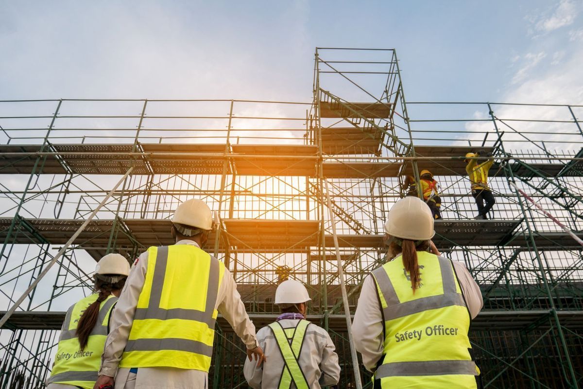 Yellow construction crane and scaffolding against blue sky